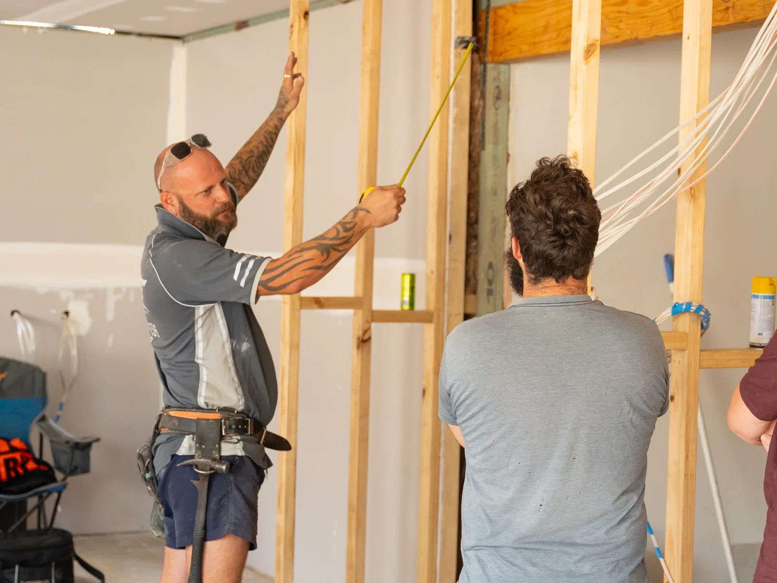Two ORT Constructions carpenters setting out a new internal wall frame during the renovation