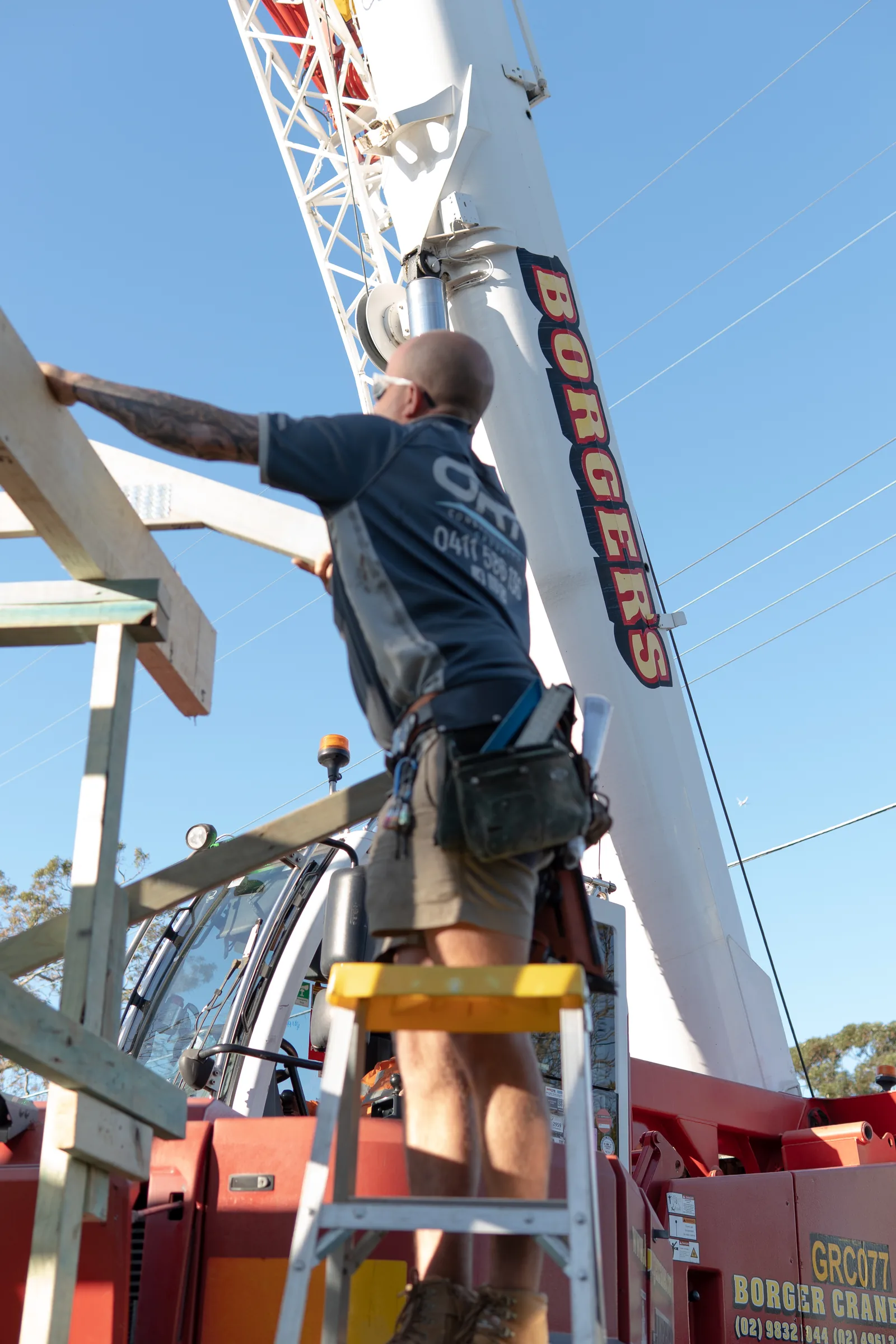 Crane lifting building materials over the site during the home rebuild