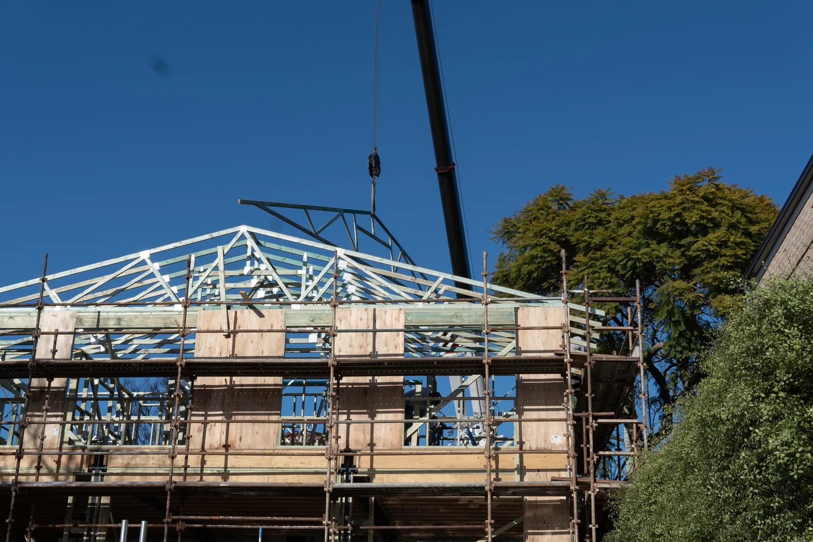 Roof trusses being craned into place on a Sydney home rebuild