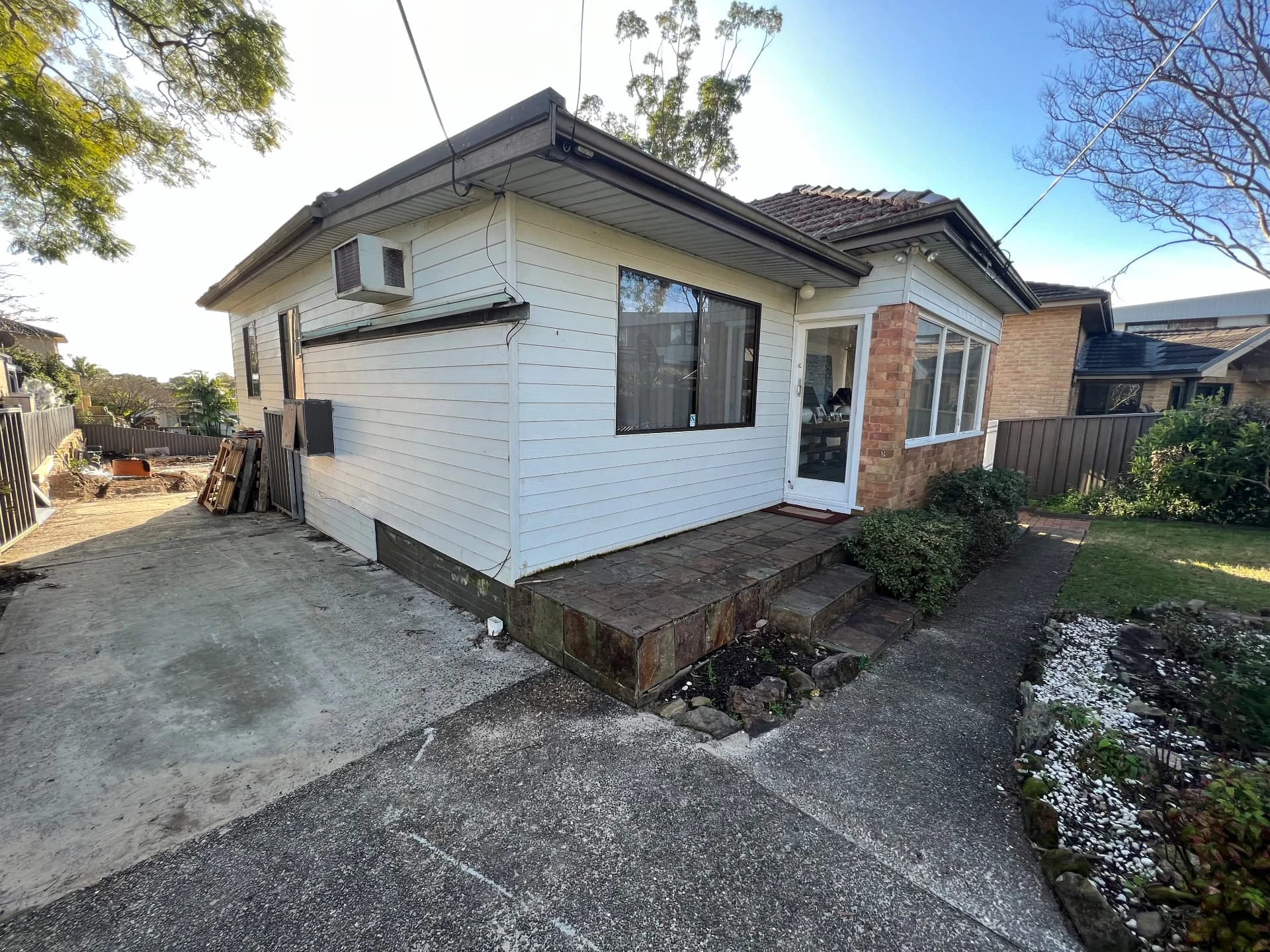 Original weatherboard cottage at Gymea Bay before demolition, showing the old side entry and paved landing