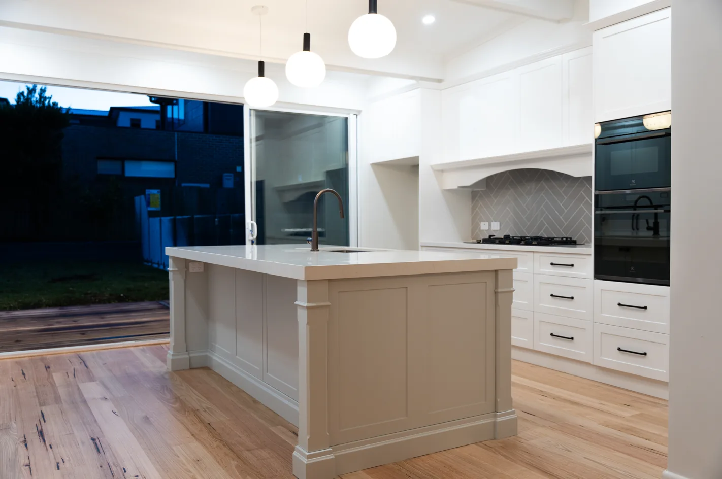 Renovated open plan kitchen and living area at dusk