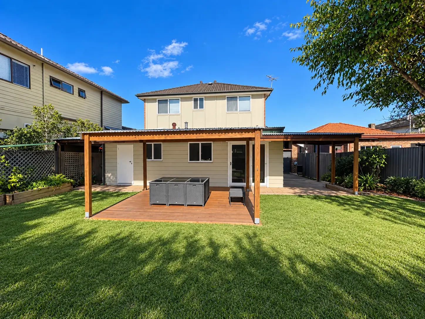 Completed timber deck and covered outdoor living area overlooking the lawn at Russell Lea