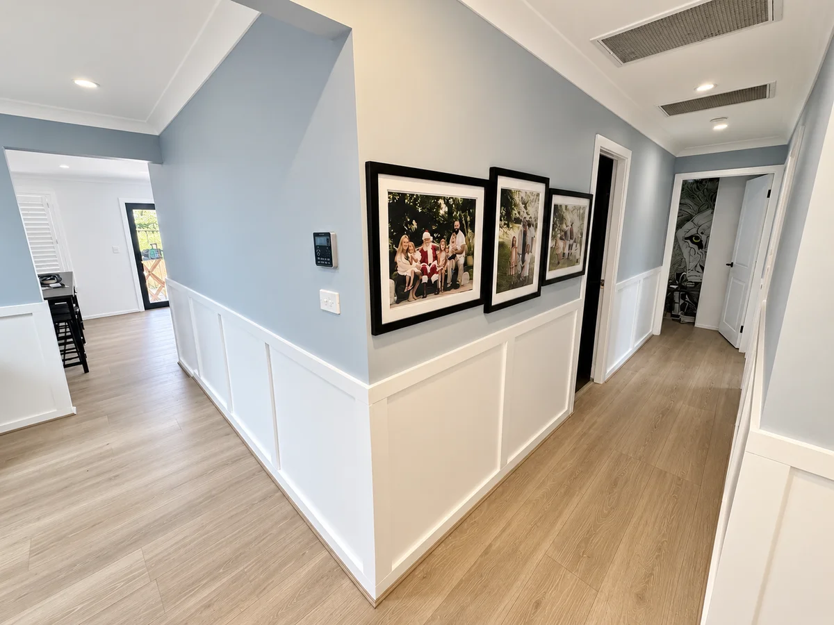 Hallway at Werrington County with white wall panelling and new timber look flooring