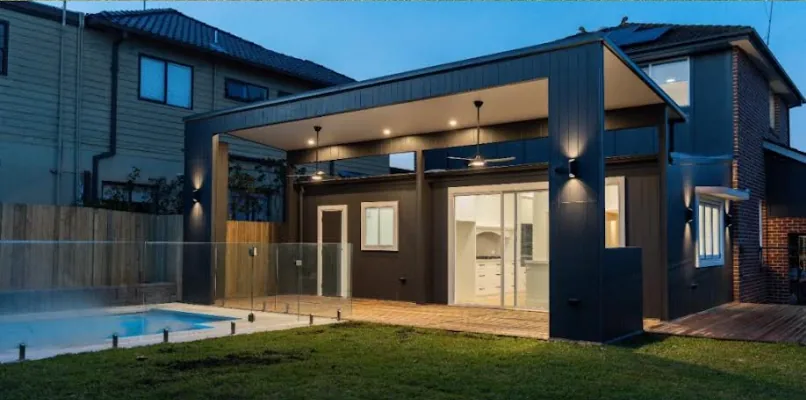 Rear home extension with open living area lit at dusk in Sydney